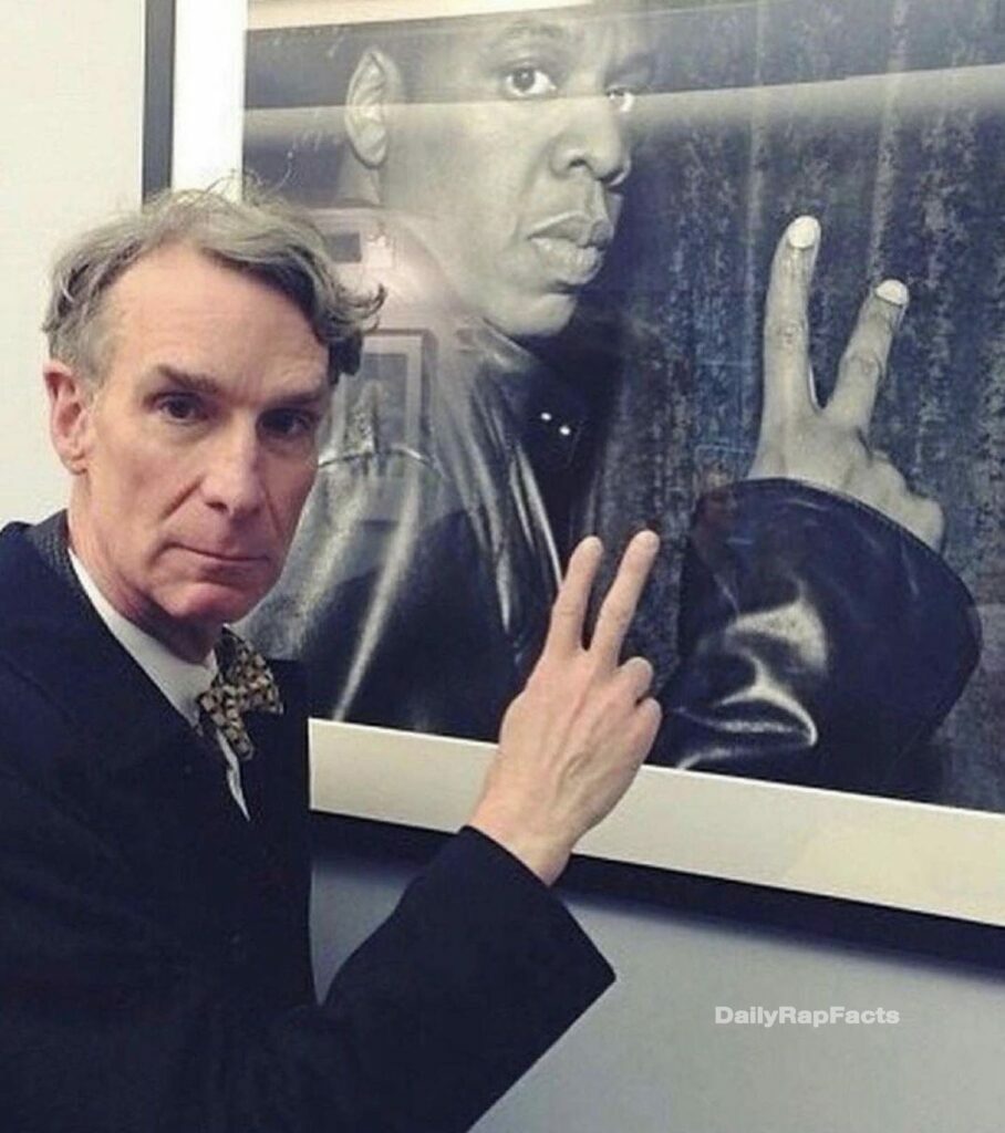 Bill Nye next to a framed photo of Jay-Z